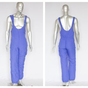 May include: Blue ski overalls with adjustable straps and side pockets.