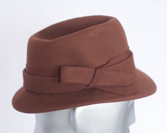 May include: A brown felt fedora hat with a wide brim and a brown ribbon bow.