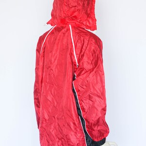 May include: Red hooded jacket with black and white trim. The jacket has a zipper closure and a drawstring hood.