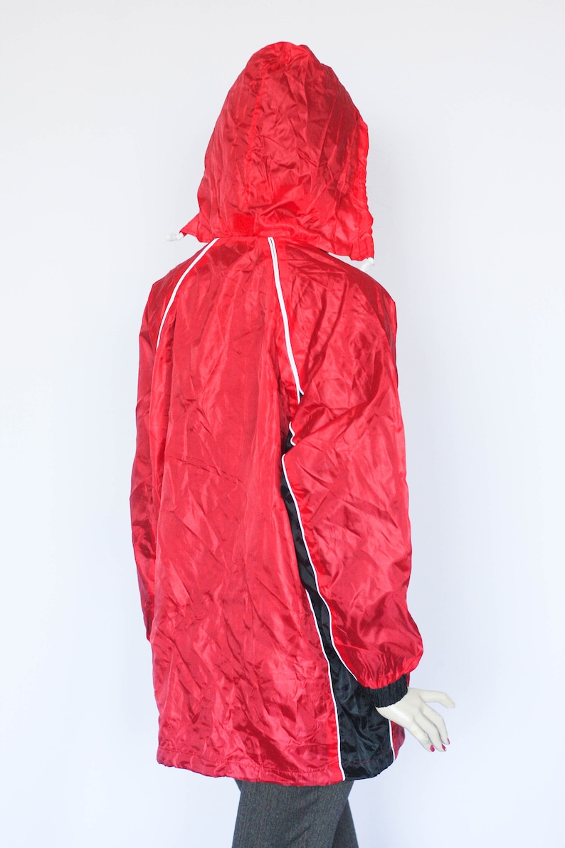 May include: Red hooded jacket with black and white trim. The jacket has a zipper closure and a drawstring hood.