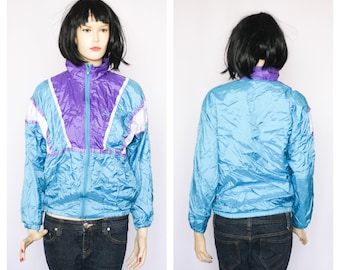 May include: A blue, purple, and white windbreaker jacket with a zipper closure. The jacket has a shiny, iridescent finish.
