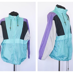 May include: A light blue, black, purple and white windbreaker jacket with a zip fastening and drawstring hood.