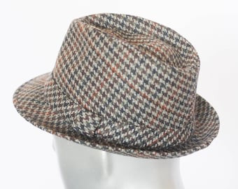 May include: A brown, black, and white patterned fedora hat.