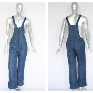 May include: Blue quilted ski overalls with adjustable straps and a zipper closure.