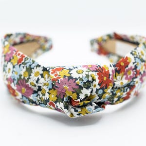 May include: A floral headband with a knotted design.