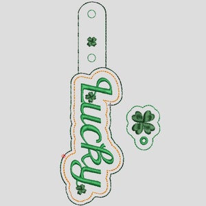 May include: A green and orange embroidered patch with the word "lucky" in a cursive font. The patch features four-leaf clovers.