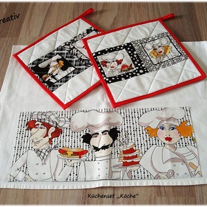 Könnte beinhalten: Ein Set aus drei weißen Küchentüchern mit rotem Rand und einem schwarz-weißen Design mit Comic-Köchen. Die Tücher haben den Text "Kuchenset "Köche" unten aufgedruckt.
