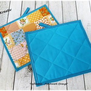 Könnte beinhalten: Zwei Topflappen, einer mit Patchwork-Muster in Orange, Gelb, Blau und Weiß, der andere einfarbig türkisblau mit Rauten-Steppung.