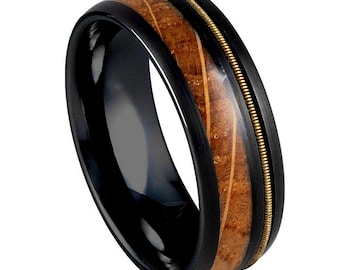 May include: A black tungsten carbide ring with a wood inlay and a gold band. The wood inlay has a natural grain pattern.