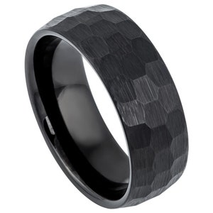 May include: A black hammered finish wedding band. The band has a textured surface and a polished interior.