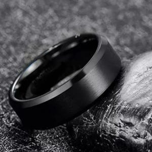May include: A black, brushed, metal ring with a beveled edge.