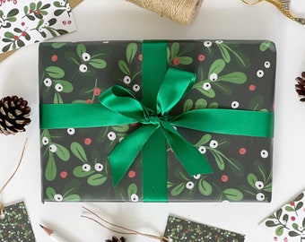 May include: A green and white gift wrap with a festive holly and berry pattern. A green ribbon is tied around the gift box with a bow.