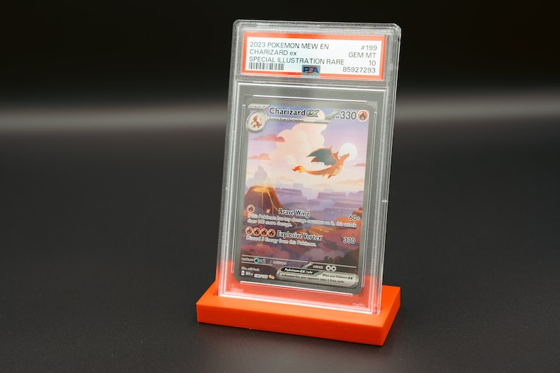 May include: A graded Pokemon trading card featuring Charizard ex from the 2023 Pokemon Mew EN set. The card is a Special Illustration Rare and is graded GEM MT 10 by PSA. The card is in a clear plastic case with a red base.