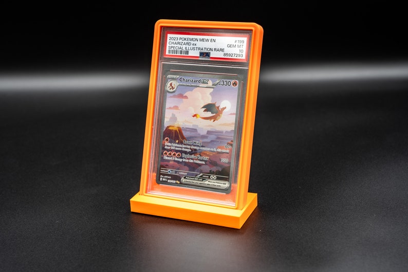 May include: A graded Pokemon card in a protective case. The card is a special illustration rare Charizard from the 2023 Pokemon Mew set. The card is graded a GEM MT 10 by PSA, with a number of 85027293.