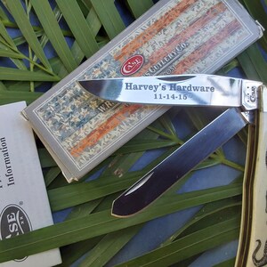 May include: A silver Case pocket knife with a bone handle. The blade is open and engraved with "Harvey's Hardware 11-14-15".
