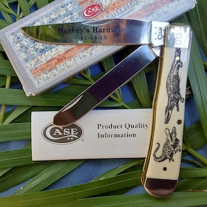 May include: A Case XX pocket knife with a bone handle featuring an alligator design. The blade is open and engraved with "Harvey's Hardware 11-14-15".