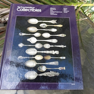 May include: The Encyclopedia of Collectibles book cover with a purple background and a close-up image of a collection of spoons. The text "Spoons" is at the bottom of the image.