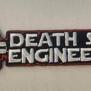 May include: Embroidered patch featuring the Death Star and the words "DEATH STAR ENGINEERING" in white lettering on a black background with a red border. The Death Star is depicted in white and black.