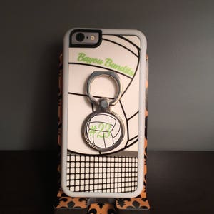 May include: White iPhone case with a volleyball design and a black and white net pattern. The case has a ring holder with the number 23 on it. The text "Bayou Bandits" is printed on the case.