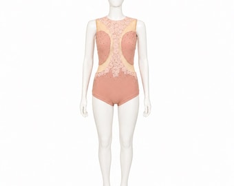 May include: A sleeveless leotard in a dusty rose color featuring a high neckline and sheer mesh panels. The garment is decorated with intricate floral lace appliques and small scattered rhinestones across the bodice and hip sections.