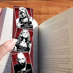 Puede incluir: Un conjunto de tres marcapáginas rojos y blancos con fotos de personajes ficticios. Las fotos de identificación incluyen los nombres "Otis Driftwood", "Vera Ellen Wood" y "Bain County".