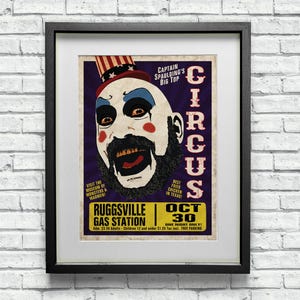 May include: A vintage-style poster advertising a circus with a creepy clown wearing a red, white, and blue hat. The poster features the text "Captain Spaulding's Big Top Circus" and "Ruggsville Gas Station Oct 30".