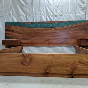 May include: A wooden bed frame with a headboard featuring a live edge design and a green epoxy river. The bed frame has two built-in nightstands.