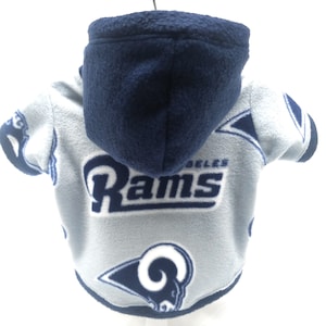 May include: A blue and gray fleece dog hoodie with the Los Angeles Rams logo. The hoodie has a hood and short sleeves.
