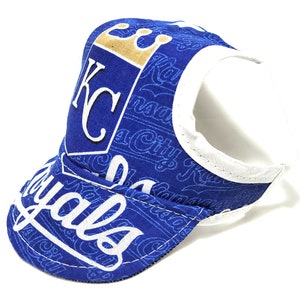 May include: Blue and white baseball cap with a Kansas City Royals logo and a crown. The cap has a white strap and a blue brim.