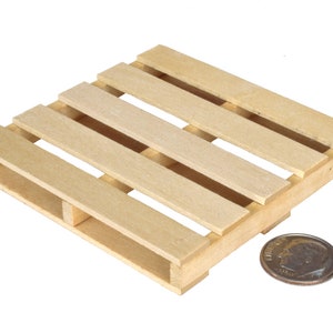 K&ouml;nnte beinhalten: Eine kleine Holzpalette, etwa 10 cm breit, aus unbehandeltem hellbraunem Holz. Eine US-Dime wird neben der Palette zur Skalierung gelegt.