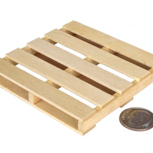 May include: A small wooden pallet, approximately the size of a US dime, made of unfinished wood.