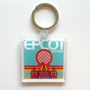 May include: A blue and yellow keychain with a white "EPCOT CENTER" logo and a red and white Spaceship Earth graphic.