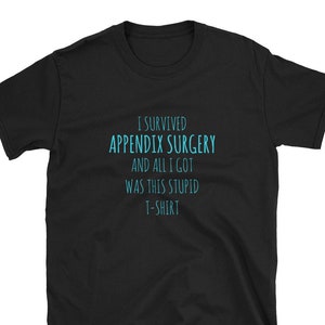 May include: Black t-shirt with the text "I SURVIVED APPENDIX SURGERY AND ALL I GOT WAS THIS STUPID T-SHIRT" in turquoise. The shirt is a short-sleeved crew neck style.