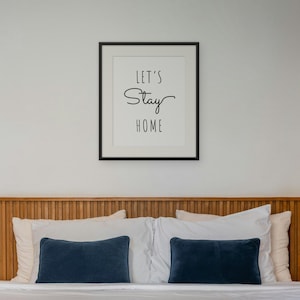 Let's Stay Home framed in a bedroom