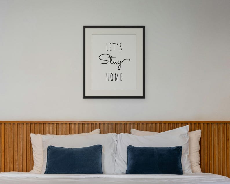 Let's Stay Home framed in a bedroom
