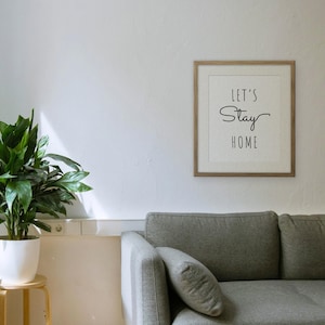 Let's Stay Home framed in a living room