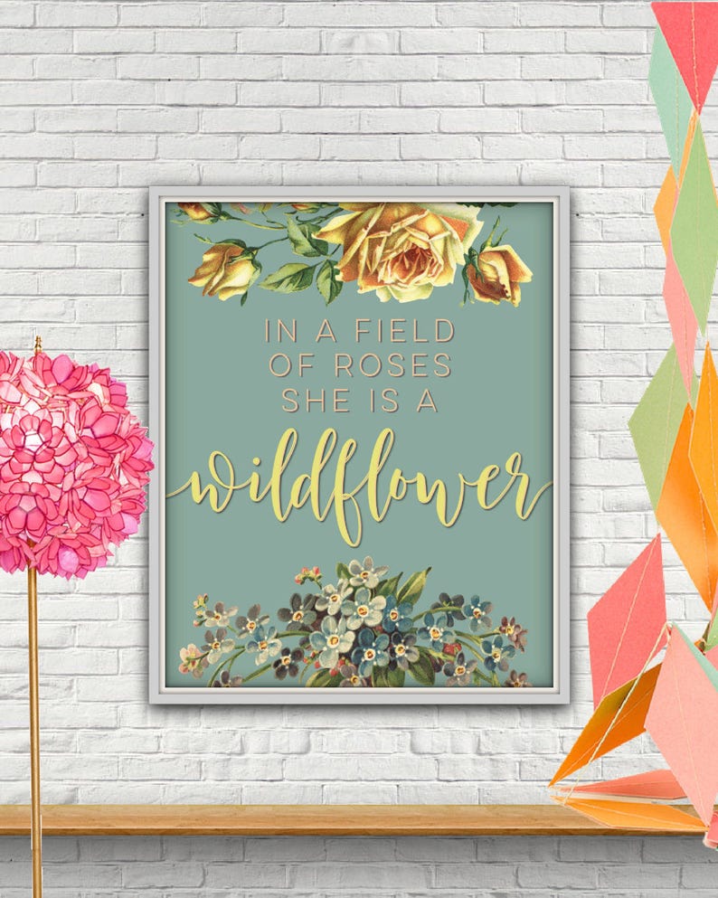 May include: A light blue printable art print with a floral design and the text "In a field of roses she is a wildflower".