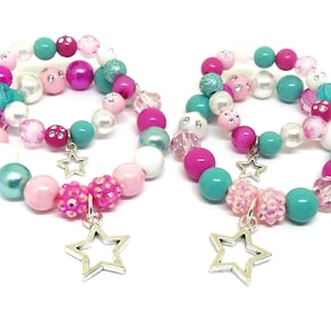 May include: Two colorful beaded bracelets with star charms. The bracelets are made with pink, turquoise, white, and iridescent beads.