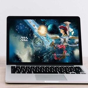 May include: A laptop computer with a blue and white space-themed desktop background featuring the zodiac sign Aquarius. The background includes a woman with wings, planets, and stars.
