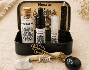 May include: A black metal tin containing a glass bottle with cork stopper labeled Hecate Herb Mix, a dropper bottle labeled Hecate Altar Oil, a small spray bottle, and a black honeycomb candle. Includes a brass key, a silver pentacle charm, and stones.