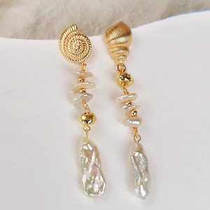 May include: Gold tone earrings with a seashell charm, white baroque pearls, and gold beads.