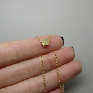 May include: A gold chain necklace with a small, round pendant.