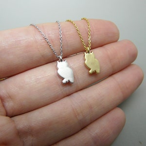 May include: Two owl pendant necklaces. One is silver-colored, the other is gold-colored. Each pendant is a silhouette of an owl, hanging from a delicate chain. The necklaces are displayed on a light background.