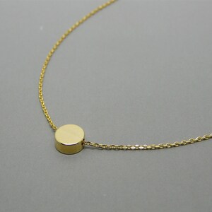 May include: A gold chain necklace with a small, round pendant.