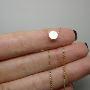 May include: A gold chain necklace with a small, round pendant.