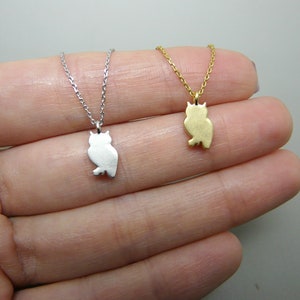 May include: Two owl pendant necklaces. One is silver-colored, the other is gold-colored. Each necklace features a small, stylized owl pendant suspended from a delicate chain. The pendants are approximately 0.75 inches in height.
