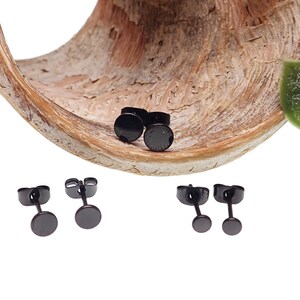 May include: Three pairs of black stud earrings. The earrings are small and round, with a smooth, polished finish.