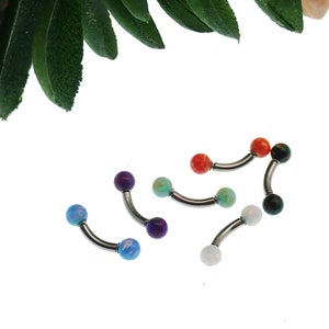 May include: A collection of four curved barbell body jewelry pieces featuring metallic silver-toned shafts and spherical ends. Each end is adorned with a smooth, colorful opal-like stone in shades of blue, purple, light green, orange, and white.