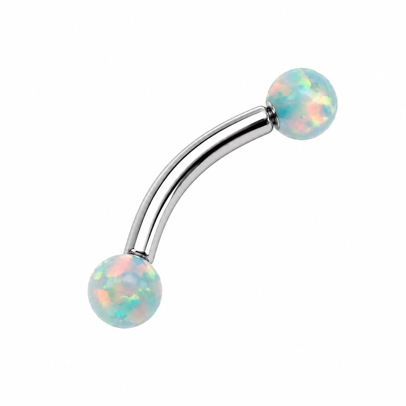 May include: A curved barbell body jewelry piece featuring a polished silver-tone metal shaft with a spherical opal bead at each end. The opal beads display a translucent white base with iridescent flashes of light blue, pink, and green color.