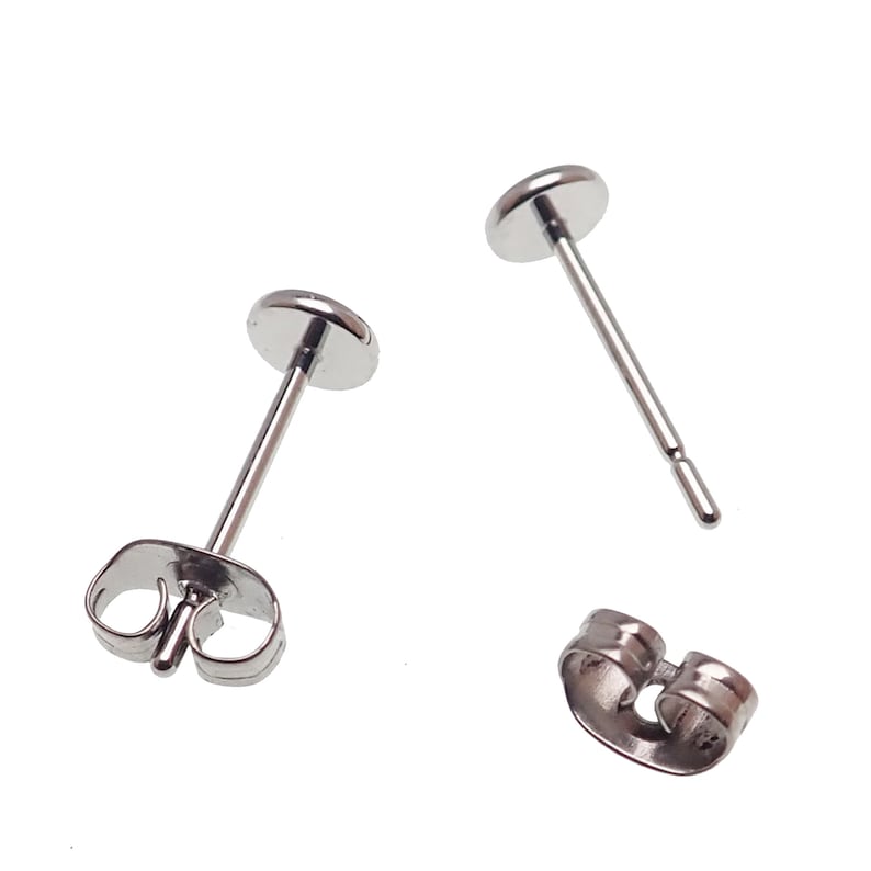 May include: A pair of silver stud earrings with a round post and a butterfly back.